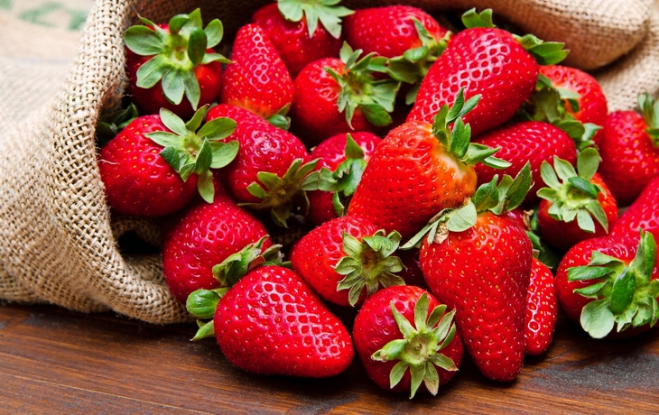 frische Erdbeeren auf Holz in Jutesack