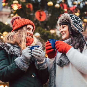 beste Freunde genießen Glühwein auf dem Weihnachtsmarkt