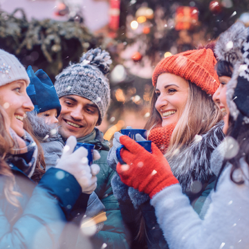 eine Gruppe von Freunden trinkt in der Kälte Glühwein auf einem Weihnachtsmarkt - © Kzenon - stock.adobe.com