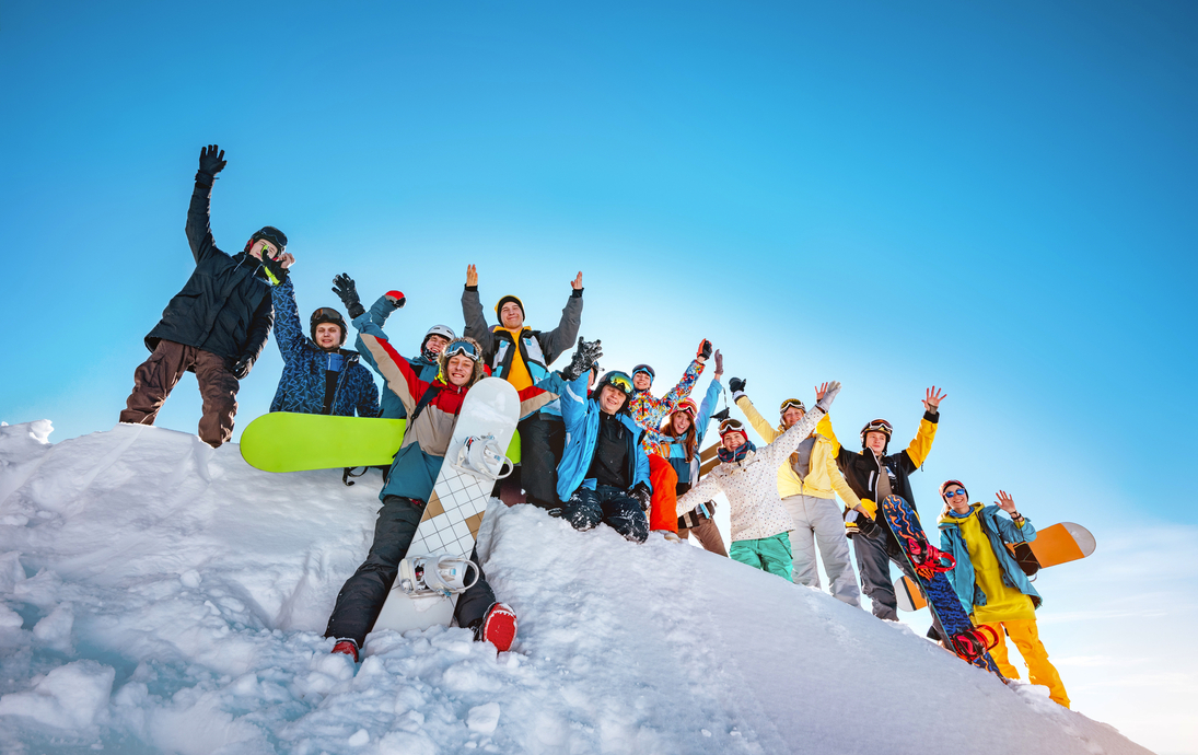 Gruppe von Skifahrern und Snowboardern im Skigebiet